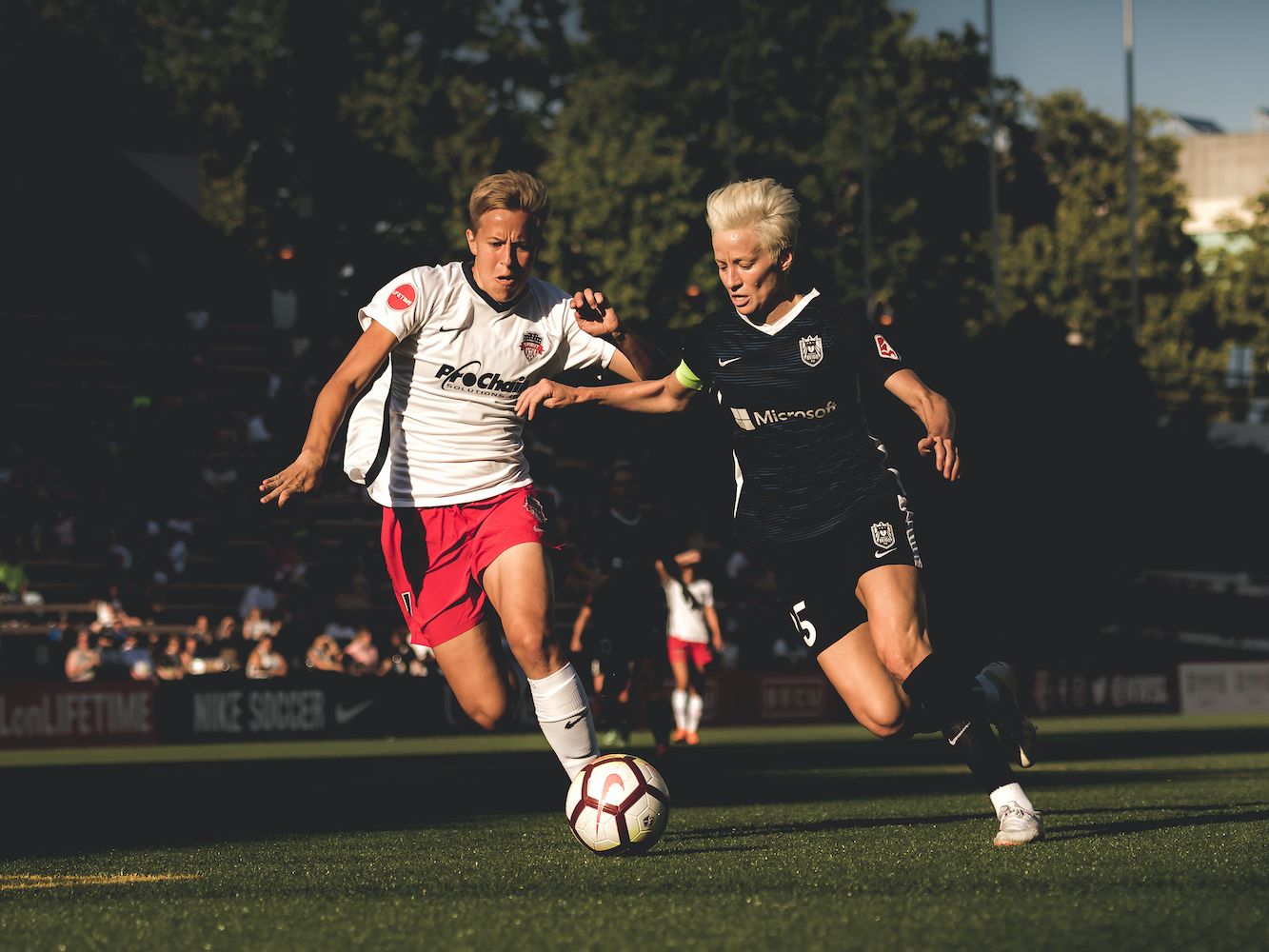 Quinn vying for possession of the soccer ball against Megan Rapinoe