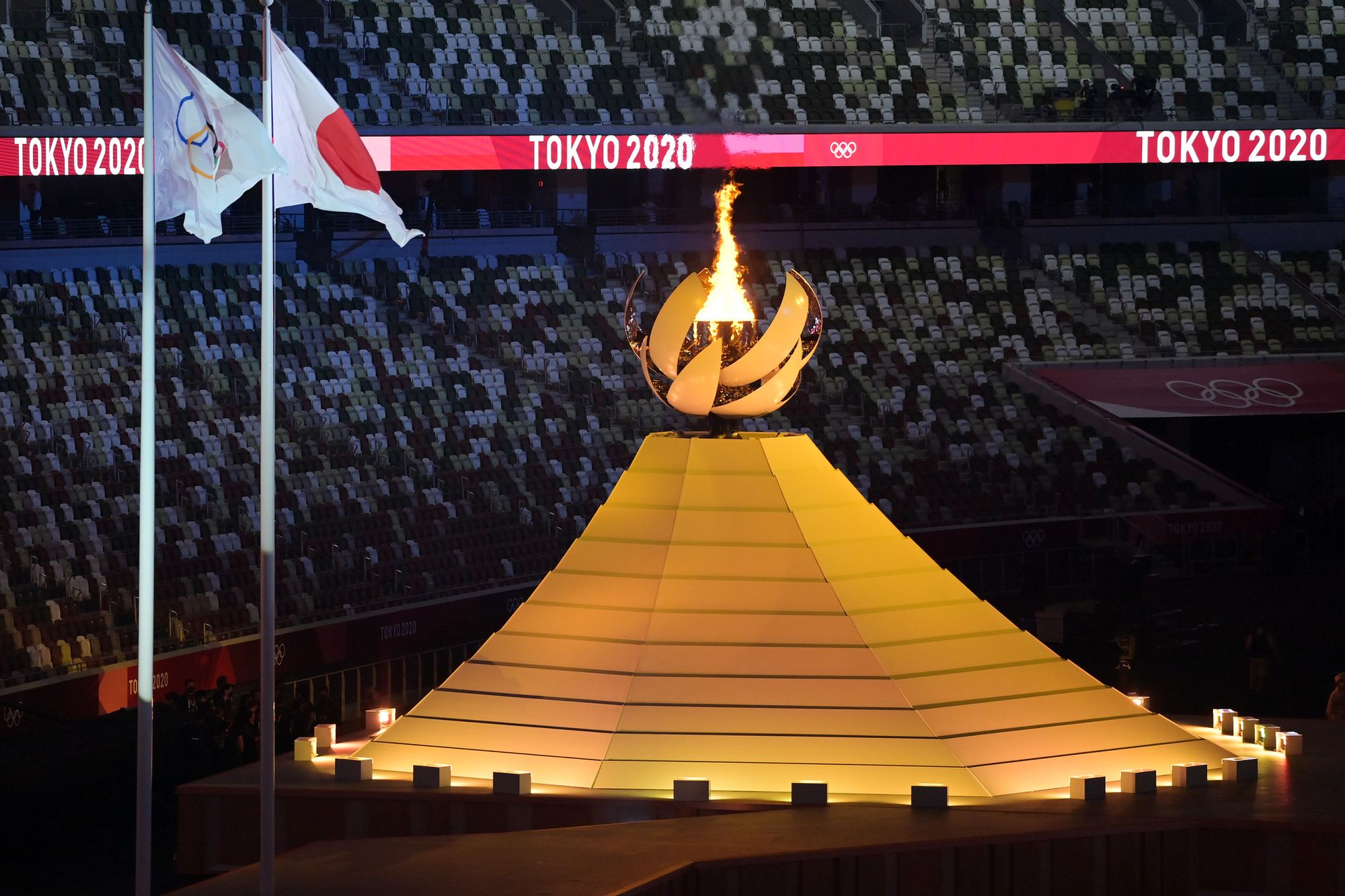The Tokyo Olympic flame burns in an empty arena.