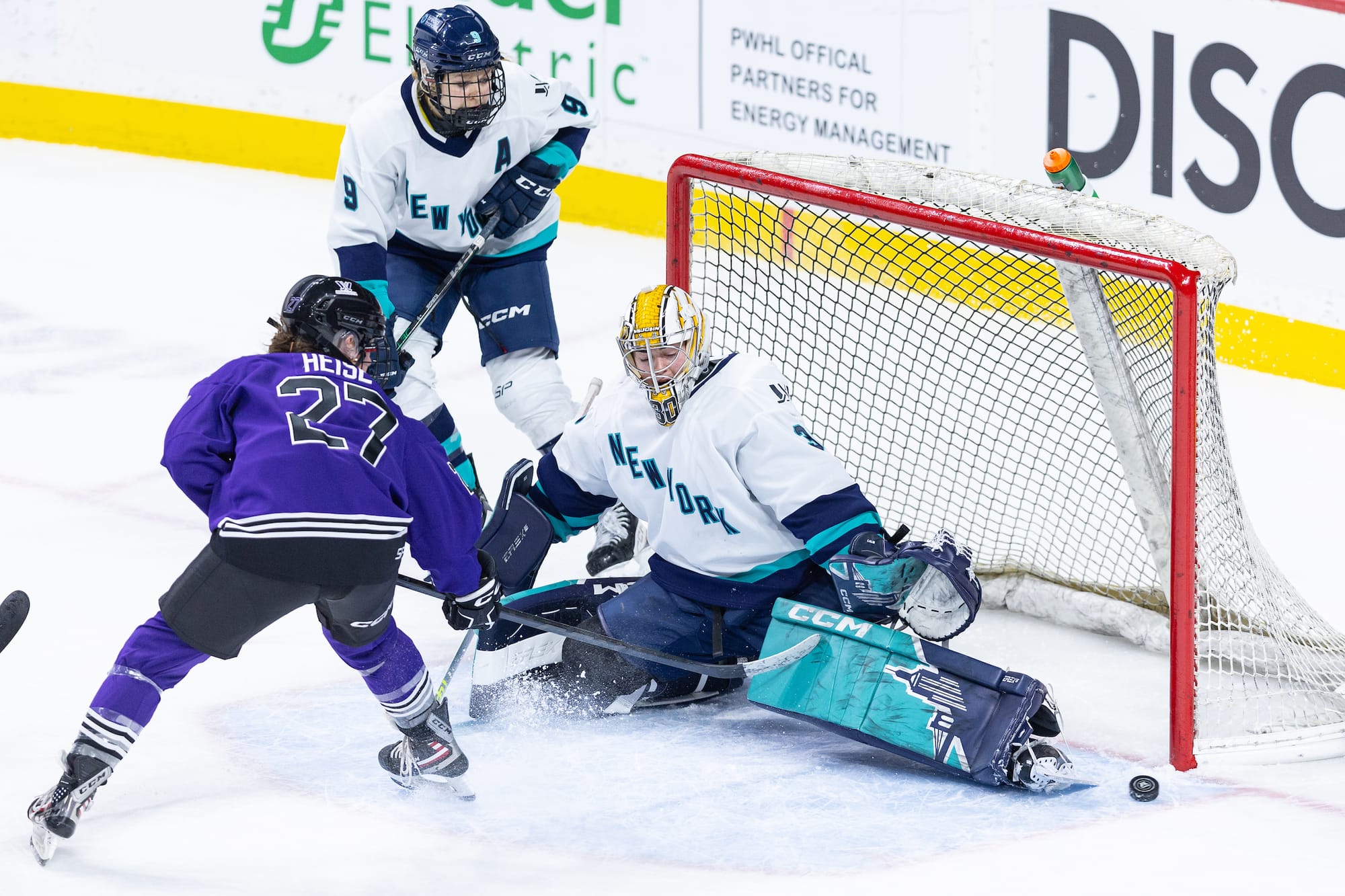Corinne Schroeder makes a toe save on Taylor Heise.