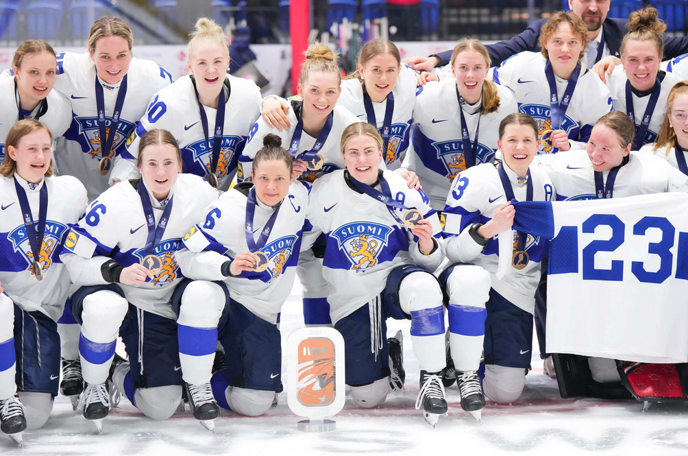 Finnish women's national team poses with their bronze medals and 3rd place trophy.